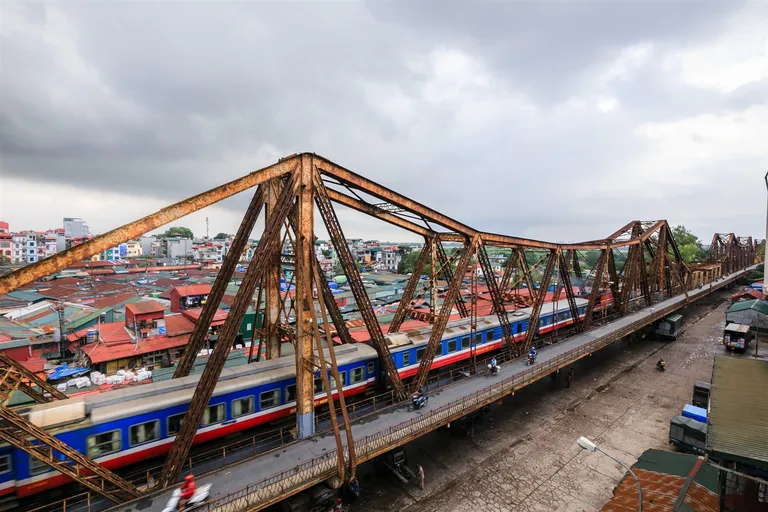 Đoàn tàu chạy trên cầu thép Long Biên, nhìn từ trên cao xuống khu dân cư hai bên.